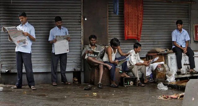 In this July 15, 2011 file photo, Indians read newspapers at Zaveri bazar, a market in Mumbai, India. India’s Ministry of Information and Broadcasting has withdrawn a sweeping new order clamping down on journalists accused of spreading fake news. The U-turn on Tuesday came hours after the ministry announced that reporters' press credentials could be suspended simply for an accusation of spreading fake news. (Photo by Aijaz Rahi/AP Photo)