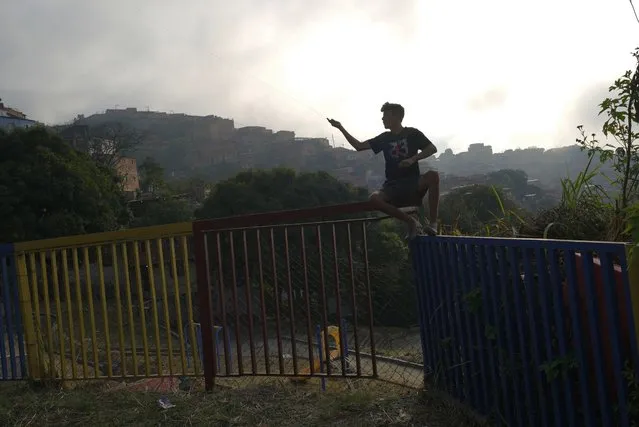 A youth flies a kite at a park in the Catia neighborhood of Caracas, Venezuela, Tuesday, February 28, 2023. (Photo by Ariana Cubillos/AP Photo)