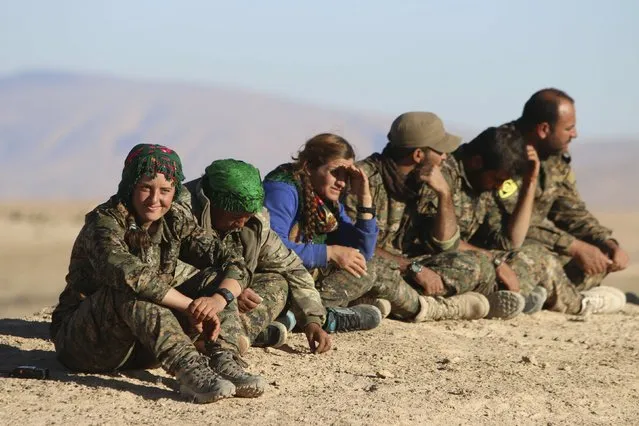 Kurdish fighters from the People's Protection Units (YPG), who are fighting alongside with the Democratic Forces of Syria, gather around the al-Khatoniyah lake area after they took control of it from Islamic State militants, near al Houl town in Hasaka province, Syria November 14, 2015. (Photo by Rodi Said/Reuters)