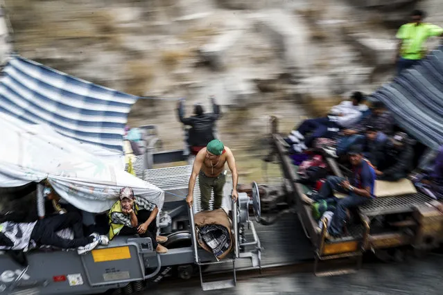 Central American migrants, who attended the annual Migrants Stations of the Cross caravan for migrants' rights, ride a northern-bound train known as "La Bestia," or The Beast, as they arrive to Hermosillo, Sonora state, Mexico, Saturday, April 21, 2018. The remnants of the migrant caravan that drew the ire of President Donald Trump were continuing their journey north through Mexico toward the U.S. border. (Photo by Luis Gutierrez/AP Photo)