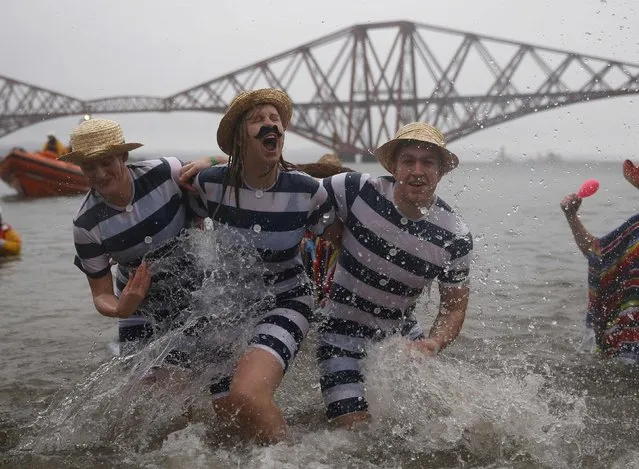 Swimmers in fancy dress splash as they participate in the New Year's Day Loony Dook swim at South Queensferry, Scotland January 1, 2015. (Photo by Russell Cheyne/Reuters)