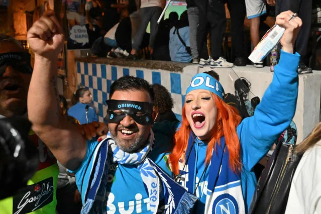 Fans of SSC Napoli gathering at the Largo Maradona in the Quartieri Spagnoli district on May 4, 2023 in Naples to watch a live broadcast of a potentially decisive match between Udinese and Napoli played in Udine, react after Napoli scored an equalizer, anticipating the celebration of the club's Italian champions “Scudetto” title, as Napoli is to play a potentially decisive match in Udine. Napoli has been waiting 33 years to be named Italian champions, and a potentially decisive game on May 4 against Udinese in Udine may secure the title. (Photo by Alberto Pizzoli/AFP Photo)