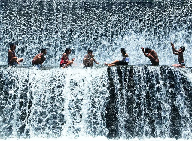 “Another Day in Paradise”. Balinese kids showering in a waterfall at Tukad Unda, Bali, Indonesia. (Photo and caption by Michael Ivan Rusli/National Geographic Traveler Photo Contest)