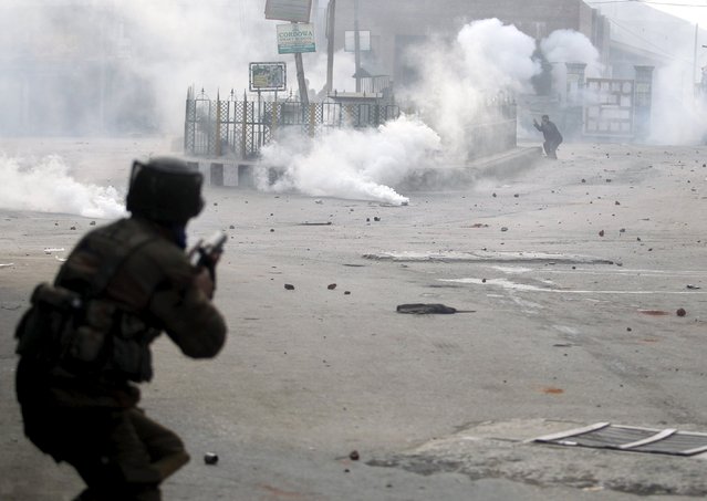 An Indian policeman fires a teargas canister towards Kashmiri demonstrators during a protest in Srinagar December 4, 2015. Indian police used teargas and fired rubber bullets to disperse hundreds of protesters after Friday prayers in downtown Srinagar against arrest of Kashmiri youths by Indian police, demonstrators said. (Photo by Danish Ismail/Reuters)