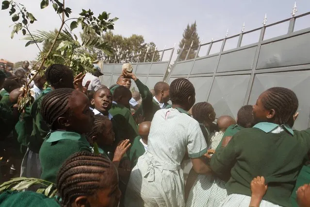 Students from Langata primary school attempt to break through a gate during a protest against a perimeter wall erected by a private developer around their school playground in Kenya's capital Nairobi, January 19, 2015. (Photo by Thomas Mukoya/Reuters)