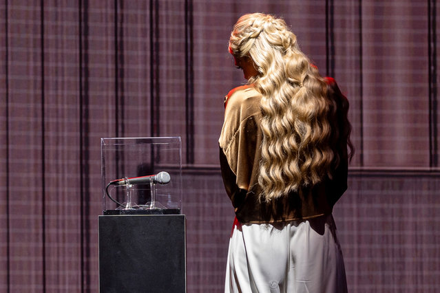 Erika Kirk stands next to the microphone which was used by Charlie Kirk at Utah Valley University on the day he was killed as she waits to greet U.S. Vice President JD Vance before closing out AmericaFest, the first Turning Point USA summit since the assassination of Charlie Kirk, in Phoenix, Arizona, U.S. on December 21, 2025. (Photo by Cheney Orr/Reuters)