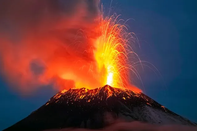 Incandescent materials, ash and smoke are spewed from the Popocatepetl volcano as seen from thr Santiago Xalitzintla community, state of Puebla, Mexico, on May 22, 2023. Mexican authorities on May 21 raised the warning level for the Popocatepetl volcano to one step below red alert, as smoke, ash and molten rock spewed into the sky posing risks to aviation and far-flung communities below. Sunday's increased alert level – to “yellow phase three” – comes a day after two Mexico City airports temporarily halted operations due to falling ash. (Photo by Erik Gomez Tochimani/AFP Photo)