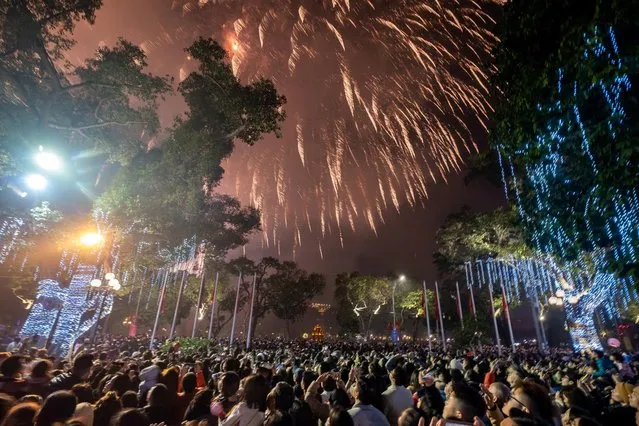 People watch a firework display to mark the Lunar New Year celebrations of the Year of the Cat in the Old Quarter on January 22, 2023 in Hanoi, Vietnam. The Lunar New Year also known as the Spring Festival or Chinese New Year, which is based on the Lunisolar Chinese calendar, falls on January 22 this year and marks the Year of the Cat in Vietnam or the Year of the Rabbit in China, Korea, and other East and Southeast Asian countries. (Photo by Linh Pham/Getty Images)