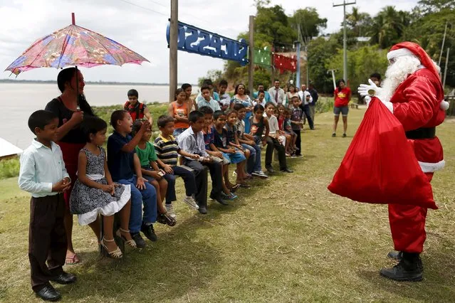 Claudionor Jose de Deus, wearing a Santa Claus costume, arrives at Santa Rosa community to distribute presents to children, on the shores of the Amazon River in rural Manaus, Brazil, December 19, 2015. (Photo by Bruno Kelly/Reuters)