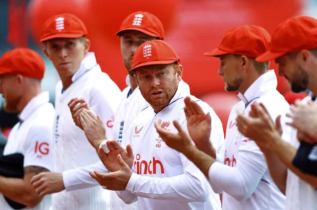 England’s Jonny Bairstow, centre, leads applause among teammates at Lord’s on day two in the 2nd Ashes Test to mark Red for Ruth Day, a show of support for The Ruth Strauss Foundation in London, Britain on June 29, 2023. It was launched by the former captain Andrew Strauss in memory of his wife, who died at 46 of incurable non-smoking lung cancer. (Photo by Matthew Childs/Action Images via Reuters)