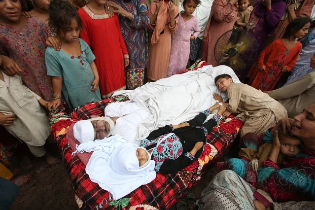 People mourn the deaths of their family members in Peshawar, Pakistan, Friday, July 20, 2018. Heavy rain resulted in roof collapsing and has killed a father and daughter while injuring son, police said. (Photo by Muhammad Sajjad/AP Photo)