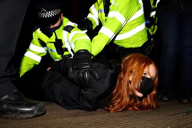 Police detain a woman as people gather at a memorial site in Clapham Common Bandstand, following the kidnap and murder of Sarah Everard, in London, Britain March 13, 2021. Yesterday, the Police confirmed that the remains of Ms Everard were found in a woodland area in Ashford, a week after she went missing as she walked home from visiting a friend in Clapham. Metropolitan Police Officer Wayne Couzens has been charged with her kidnap and murder. (Photo by James Veysey/Rex Features/Shutterstock)