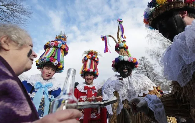 Revellers are offered drinks during a traditional carnival celebrating the departing winter and forthcoming spring at an open-air museum in the village of Vesely Kopec, near the east Bohemian city of Hlinsko, Czech Republic January 31, 2015. The festival was added to the UNESCO list of world heritage in 2010. (Photo by David W. Cerny/Reuters)