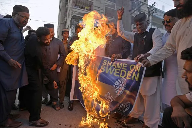 Activists of the United Muslim Forum Pakistan group burn a representation of Swedish flag during a demonstration in Karachi, Pakistan, Sunday, July 2, 2023, against desecration of Islam's holy book “Quran” in Sweden. (Photo by Fareed Khan/AP Photo)