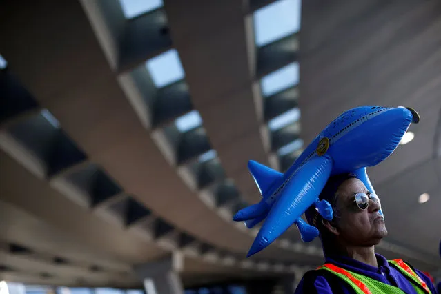 Demonstrator Oscar Sandoval wears an inflatable toy airplane on his head during a protest calling for higher pay and union rights for baggage handlers and cabin cleaners at O'Hare Airport in Chicago, Illinois, U.S., November 29, 2016. (Photo by Jim Young/Reuters)