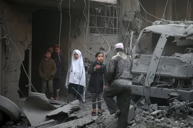Children inspect damage in a site hit by what activists said were airstrikes carried out by the Russian air force in the town of Douma, eastern Ghouta in Damascus, Syria January 10, 2016. (Photo by Bassam Khabieh/Reuters)