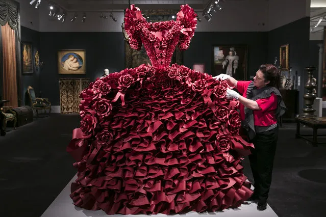 British Artist Zoe Bradle makes finishing touches to her monumental red paper dress sculpture containing 5,940 ruffles at Sotheby's on January 14, 2016 in London, England. (Photo by John Phillips/Getty Images for Sotheby's)