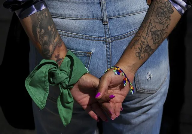 An abortion-rights advocate wears a green kerchief outside the U.S. embassy to protest the U.S. Supreme Court's overturning of Roe v. Wade, which removed women's constitutional protections for abortion in the U.S., in Mexico City, Wednesday, June 29, 2022. (Photo by Fernando Llano/AP Photo)