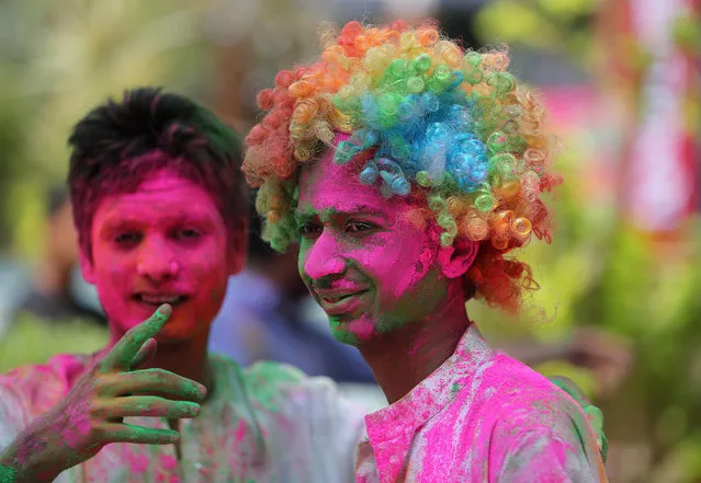 Indians stand with their faces smeared with coloured powder during Holi celebrations in Hyderabad, India, Friday, March 6, 2015. Holi, the Hindu festival of colors, also marks the advent of spring. (AP Photo/Mahesh Kumar A.)