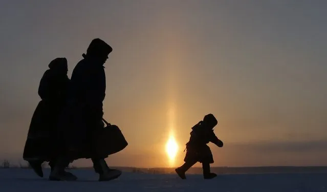 In this photo taken on Sunday, March 15, 2015, a Nenets family walks after the Reindeer Herder's Day holiday in the city of Nadym, in Yamal-Nenets Region, 2500 km (about 1553 miles) northeast of Moscow, Russia. (Photo by Dmitry Lovetsky/AP Photo)