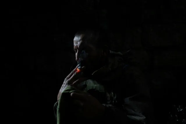 A Ukrainian serviceman smokes a cigarette while taking a cover from shelling in a bunker at the frontline in Andriivka, Donetsk region, Ukraine, Saturday, September 16, 2023. (Photo by Alex Babenko/AP Photo)