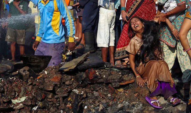 An Indian woman cries while her baby is missing after a fire in Ambedkar Nagar slum in Mumbai, India, 21 November 2013. According to reports, a fire broke out in the area on 21 November, gutting shanties, but no casualties have been reported. (Photo by Divyakant Solanki/EPA)