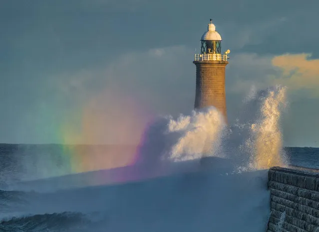 Large waves crash onto Tynemouth Pier and lighthouse in the North East, UK as the sun was setting on Saturday, October 14, 2023, with the sea spray creating a rainbow. (Photo by Ian Sproat/Picture Exclusive)