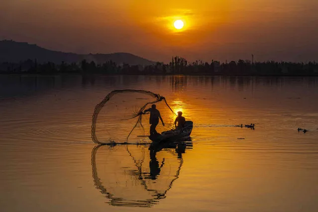 A Kashmiri fisherman casts his net during sunset on the Dal Lake in Srinagar, Indian controlled Kashmir, Friday, September 1, 2023. (Photo by Dar Yasin/AP Photo)