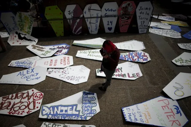 A woman walks through a field of cardboard coffins to commemorate the more than 617 people march organizers say have been killed by law enforcement in LA County since 2000, in Los Angeles, California April 7, 2015. (Photo by Lucy Nicholson/Reuters)