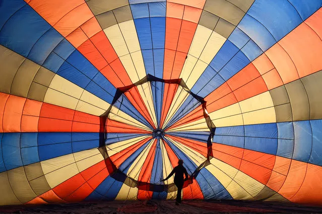 A hot-air balloon is inflated at the International Balloon Fiesta in Bristol, United Kingdom on August 4, 2021. (Photo by James Veysey/Rex Features/Shutterstock)