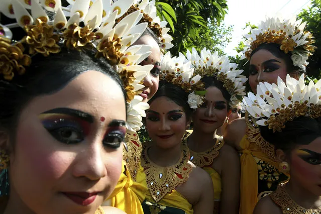 Dancers in traditional dress pose for a photo, during a cultural festival parade in the village of Denpasar, Bali, Indonesia on Saturday, November 18, 2023. (Photo by Firdia Lisnawati/AP Photo)