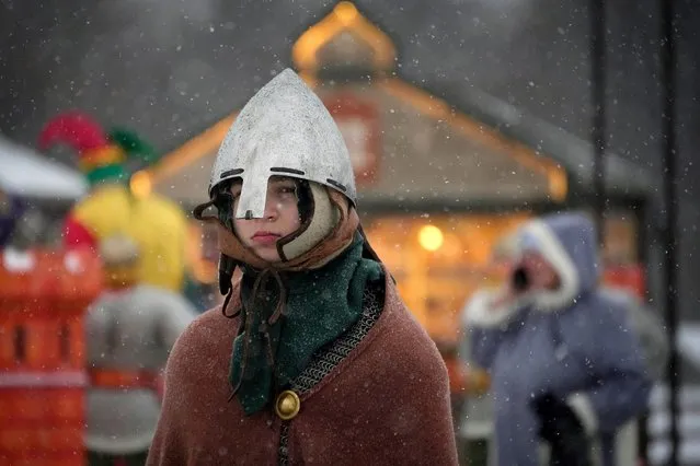 A boy dressed as a Russian knight walks at a Christmas market opened prior to incoming Christmas and New Year festivities in St. Petersburg, Russia, Friday, December 22, 2023. (Photo by Dmitri Lovetsky/AP Photo)