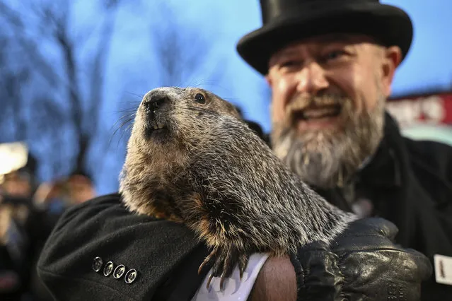 Groundhog Club handler A.J. Dereume holds Punxsutawney Phil, the weather prognosticating groundhog, during the 138th celebration of Groundhog Day on Gobbler's Knob in Punxsutawney, Pa., Friday, February 2, 2024. Phil's handlers said that the groundhog has forecast an early spring. (Photo by Barry Reeger/AP Photo)