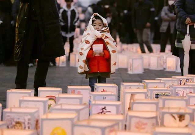 A little girl looks at candle lanterns, during a memorial ceremony for tsunami victims at the tsunami-devastated city of Natori, Miyagi Prefecture, Northern Japan, 11 March 2016. Japan marks the fifth anniversary of the earthquake and tsunami. Japan's National Police Agency announced that as of February 2016, 15,894 people were killed in the disaster, 2,562 are still missing, and some 174,471 people are still living in shelters. (Photo by Kimimasa Mayama/EPA)