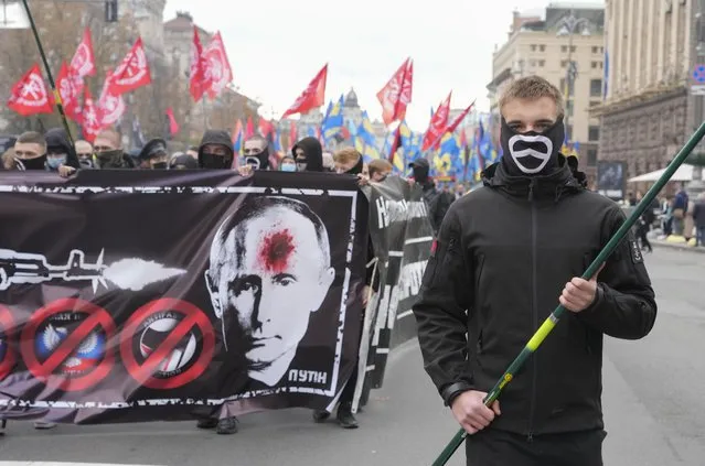 Members of nationalist movements march during a rally marking Defender of Ukraine Day, in center Kyiv, Ukraine, Thursday, October 14, 2021. Some 15,000 far-right and nationalist activists marched in the Ukrainian capital, chanting “Glory to Ukraine” and waving yellow and blue flags. (Photo by Efrem Lukatsky/AP Photo)