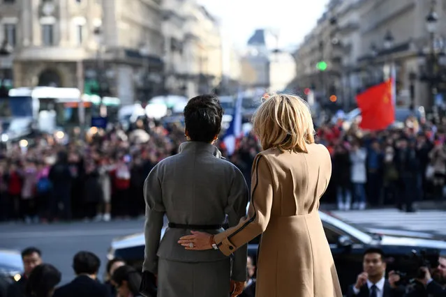 French president's wife Brigitte Macron and Chinese president's wife Peng Liyuan wave to the crowd as they visit the Palais Garnier opera house in Paris, France March 25, 2019. (Photo by Martin Bureau/Pool via Reuters)
