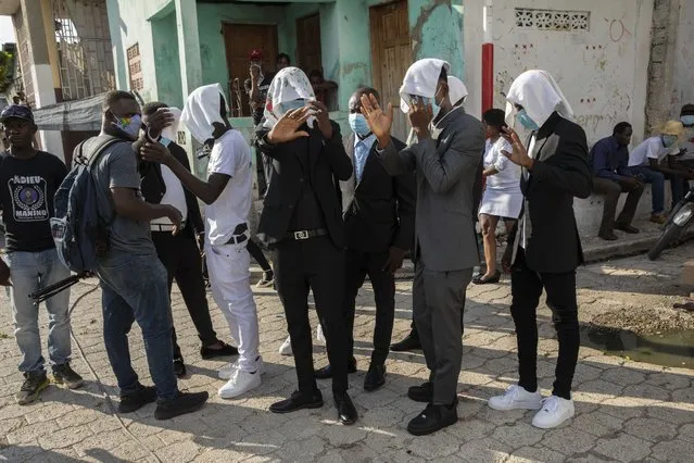 Gang members use hand towels to conceal their identity as they arrive to attend the funeral of fellow gang member Tonino Manino, in Port-au-Prince, Thursday, September 30, 2021. (Photo by Rodrigo Abd/AP Photo)