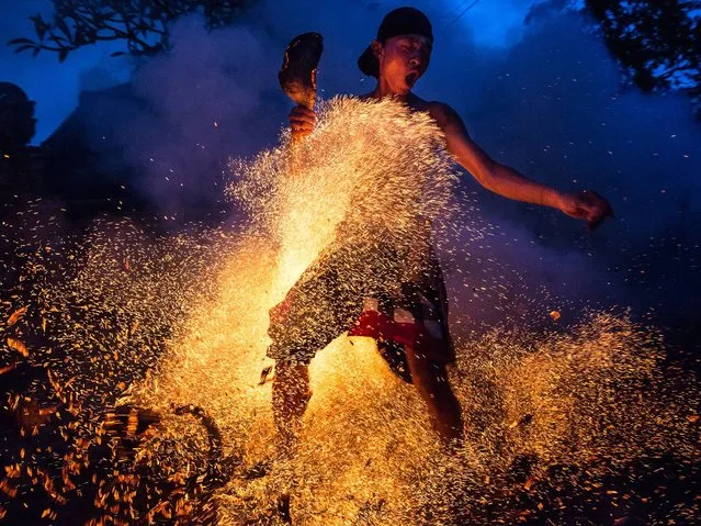 A Balinese man kicks up the fire during the “Mesabatan Api” ritual ahead of Nyepi Day on March 20, 2015 in Gianyar, Bali, Indonesia. Mesabatan Api is held annually a day before the Nyepi Day of Silence, as it symbolizes the purification of universe and human body through fire. Nyepi is a Hindu celebration observed every New Year according to the Balinese calendar. (Photo by Agung Parameswara/Getty Images)