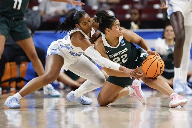 North Carolina guard Deja Kelly, left, battles Michigan State guard Moira Joiner (22) for a loose ball during the second half of a first-round college basketball game in the women's NCAA Tournament in Columbia, S.C., Friday, March 22, 2024. (Photo by Nell Redmond/AP Photo)