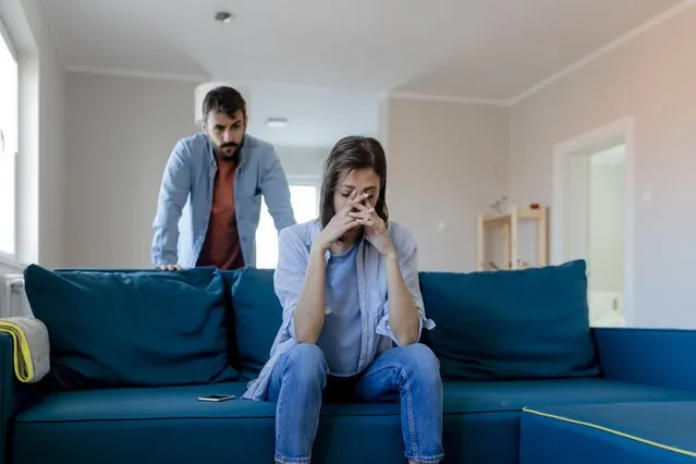 Angry fury man screaming at woman. Angry couple having an argument in their living room. Young marriage couple have an argument because of relationship crisis. Couple having argument – conflict, bad relationships. (Photo by PixelsEffect/Getty Images)