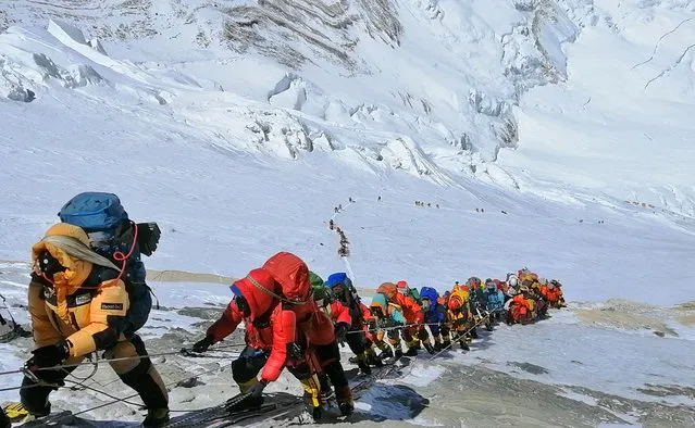 In this May 22, 2019 photo, a long queue of mountain climbers line a path on Mount Everest just below camp four, in Nepal. Seasoned mountaineers say the Nepal government's failure to limit the number of climbers on Mount Everest has resulted in dangerous overcrowding and a greater number of deaths. (Photo by Rizza Alee/AP Photo)