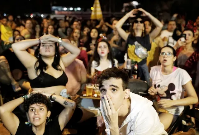 Brazilian fans of women's soccer react as they watch the soccer match between France and Brazil on a TV screen at a bar in Sao Paulo, Brazil, June 23, 2019. (Photo by Nacho Doce/Reuters)