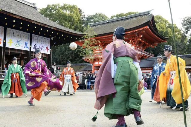 People clad in traditional attire play “kemari”, a football game played by nobles in Japan's Heian period, at Shimogamo shrine in Kyoto on January 4, 2022. (Photo by Kyodo News via Getty Images)