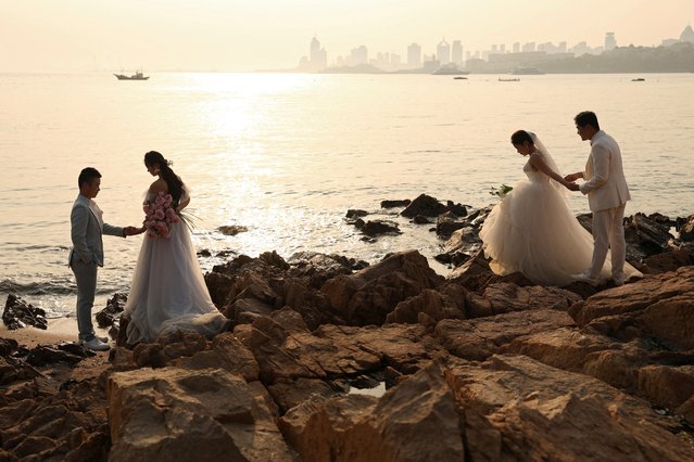 Couples take part in their pre-wedding photoshoots by the sea in Qingdao, Shandong province, China on April 21, 2024. (Photo by Florence Lo/Reuters)