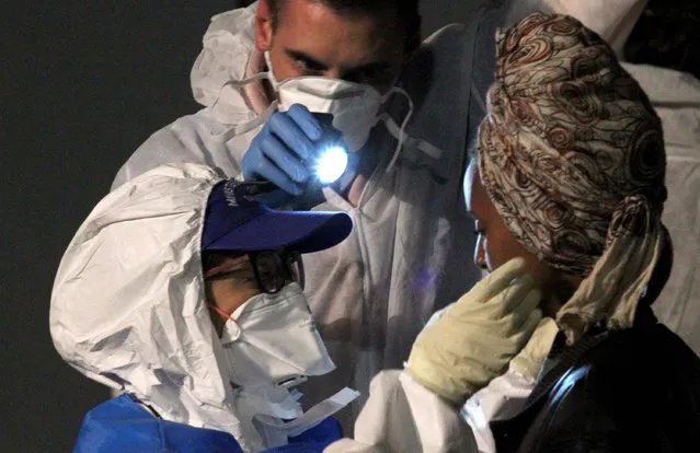 A doctor examines a woman after she disembarked from the German Navy ship Schleswig Holstein at the Reggio Calabria harbor, Italy, Tuesday, June 16, 2015. European Union nations failed to bridge differences Tuesday over an emergency plan to share the burden of the thousands of refugees crossing the Mediterranean, while on the French-Italian border, police in riot gear forcibly removed dozens of migrants. (AP Photo/Adriana Sapone) 