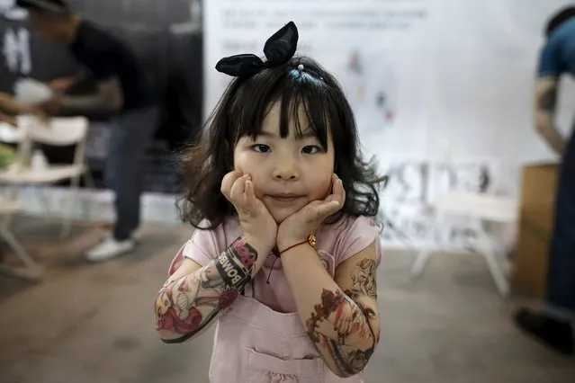 Candy Wang, 4, shows her tattoo stickers during an exhibition of 2016 Shanghai International Art Festival Of Tattoos in Shanghai, China, April 22, 2016. (Photo by Aly Song/Reuters)