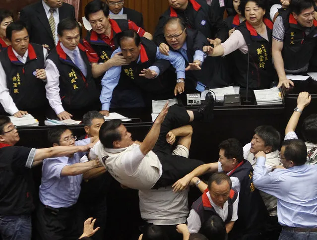 Opposition Democratic Progressive Party (DPP) legislator Kuo Wen-chen falls off the podium while scuffling with ruling Nationalist Party (KMT) legislators at the Legislative Yuan in Taipei July 8, 2010. (Photo by Nicky Loh/Reuters)