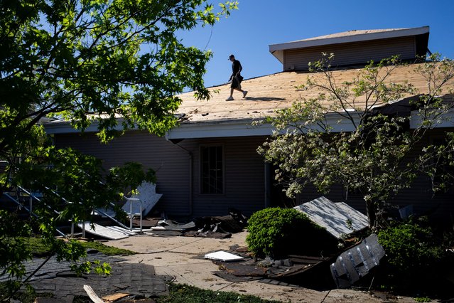 A worker tends to the roof of a building after it was severely damaged after a tornado hit the area of Portage, Michigan on May 8, 2024. (Photo by Emily Elconin/Reuters)