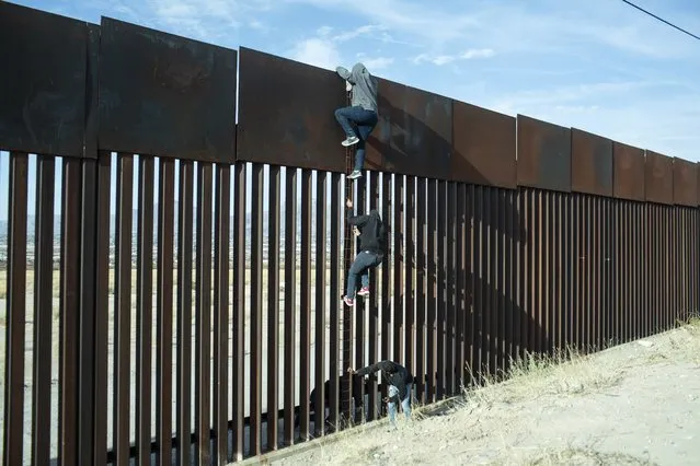Migrants climb over a border wall in Ciudad Juarez, Mexico, on Thursday, April 1, 2021. The U.S. is on track to encounter more than 2 million migrants at the US-Mexico border by the end of the fiscal year, according to internal government estimates reviewed by CNN, marking a record high. (Photo by Nicolo Filippo Rosso/Bloomberg via Getty Images)