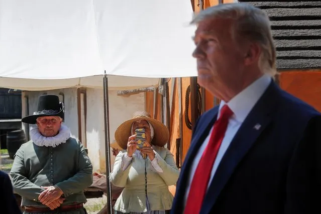 Museum employees look on as U.S. President Donald Trump participates in a tour of the James Fort Replica at the Jamestown Settlement Museum in Williamsburg, Virginia, U.S., July 30, 2019. (Photo by Carlos Barria/Reuters)